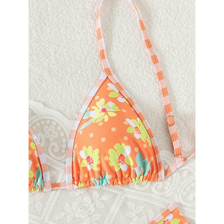 Trendig orange dambikini med vackert blommönster. Bekväma badkläder med justerbara band för sommarstil.