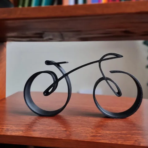 Närbild på den svarta cykelskulpturen i trådram