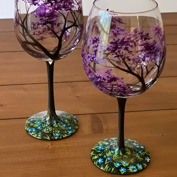Elegant vinglas i konstglas stående på bord, handmålad trädmotiv