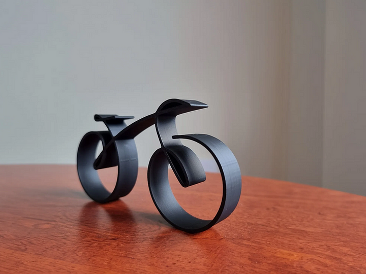 Cykelskulptur i minimalistisk design fotograferad från sidan
