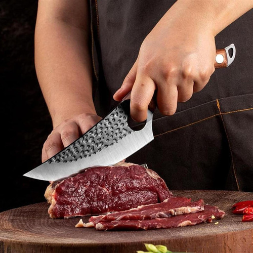 Kock som skär kött med japansk kökkniv på skärbräda