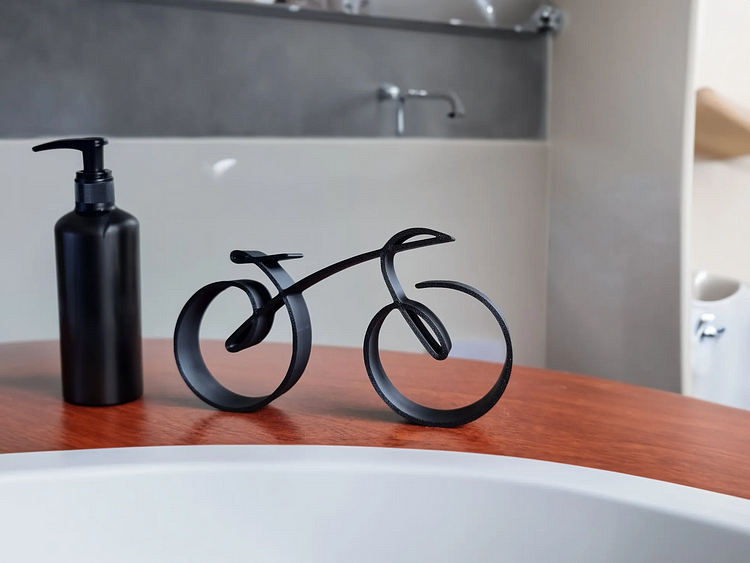 Svart cykelskulptur i trådram som elegant väggdekoration i vardagsrummet