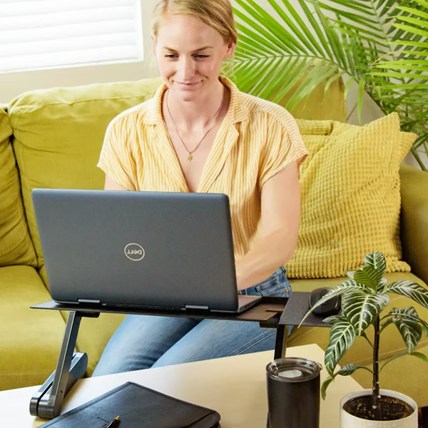 Laptop ställ uppställt med musmatta bredvid växt
