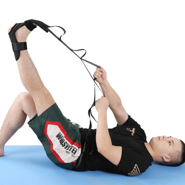 Person som använder yoga stretch strap för bensträckning på träningsmatta