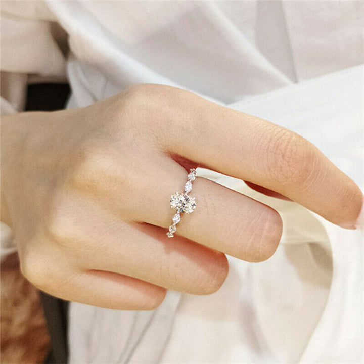 "Oval förlovningsring för damer i silver och guld med moissanite-sten och diamantbesatta band, elegant accessoar."