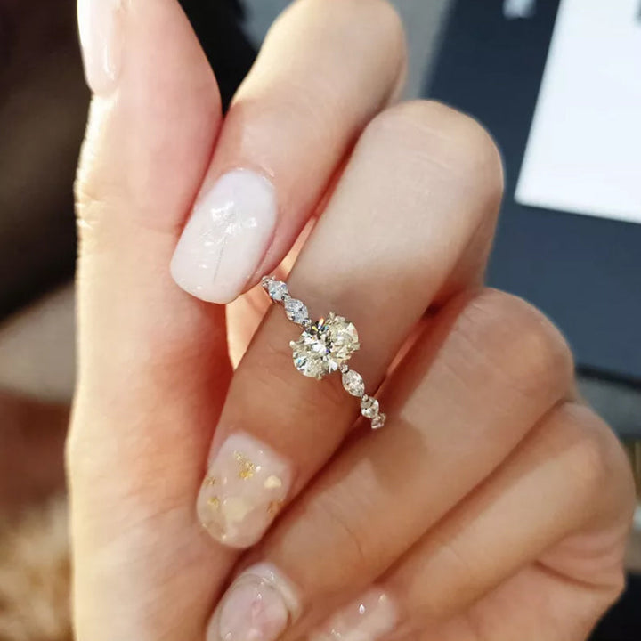 "Oval förlovningsring för damer i silver och guld med moissanite-sten och diamantbesatta band, elegant accessoar."