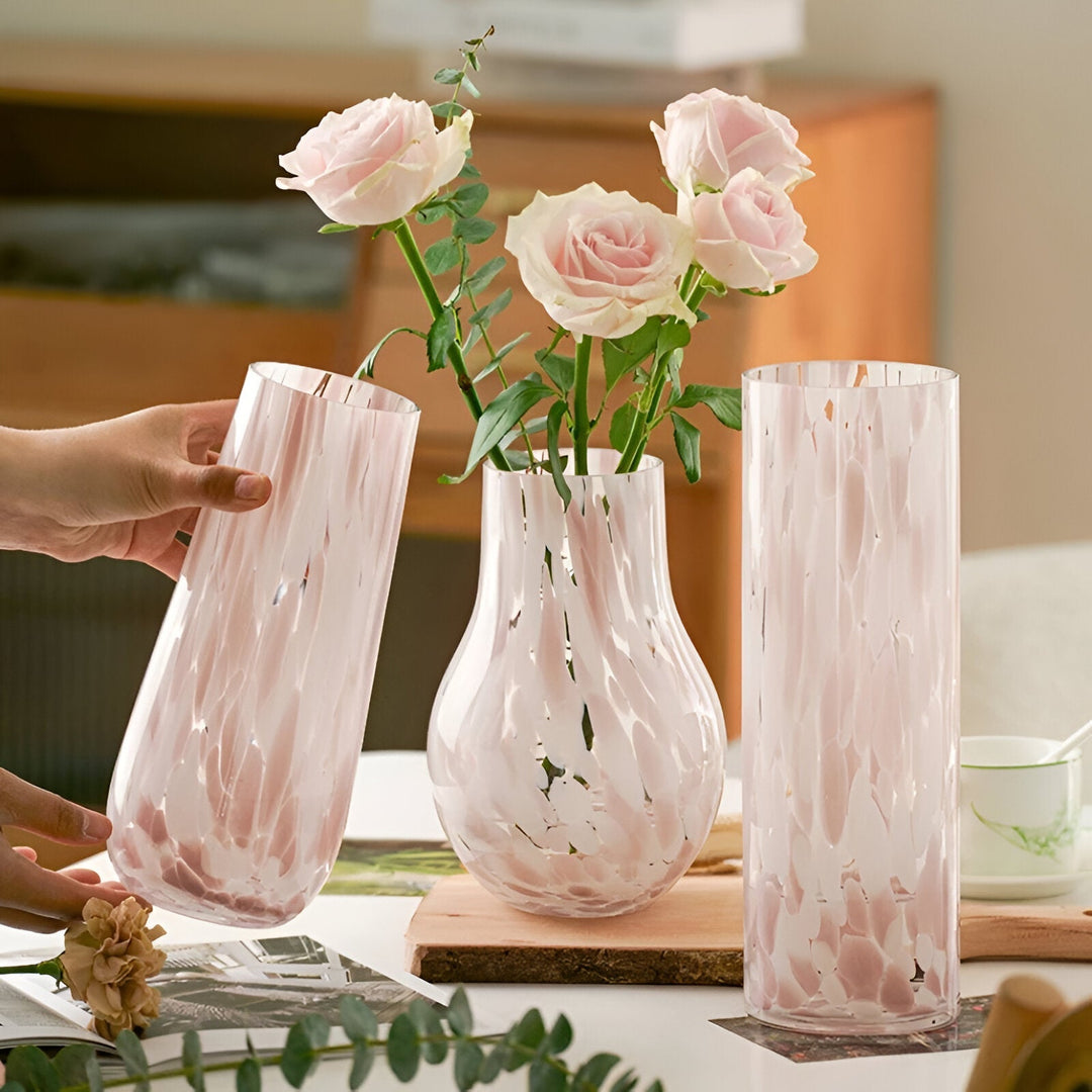 Rosa marmorerad glasvas fylld med färska rosor i modern heminredning