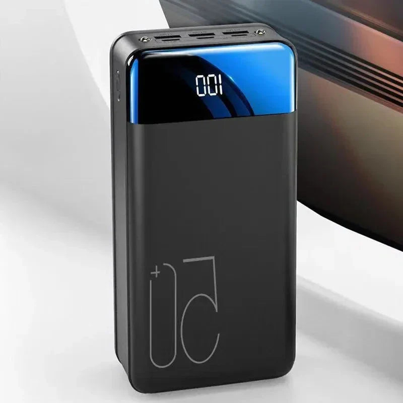 Svart powerbank med digital display som visar 100 procent