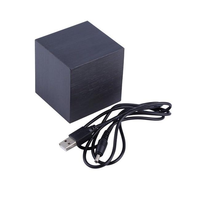 Svart LED-väckarklocka bredvid medföljande USB-strömkabel