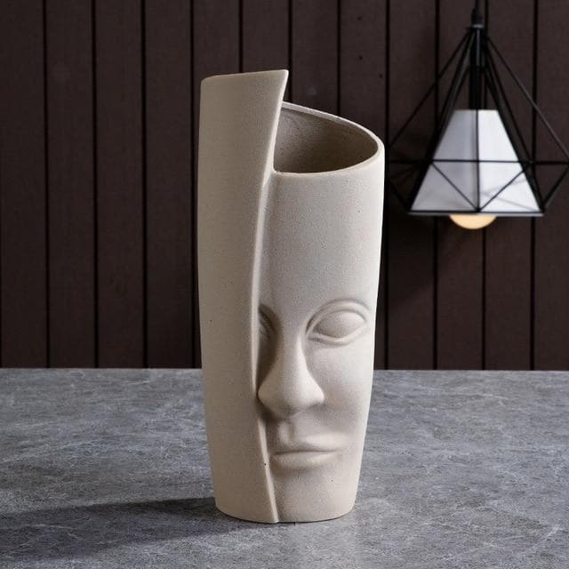 Beige skulptural hög vas med asymmetrisk topp och ansiktsrelief