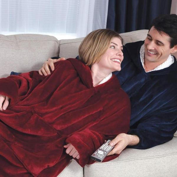 Kvinna och man som myser i soffan i varsin varm filttröja