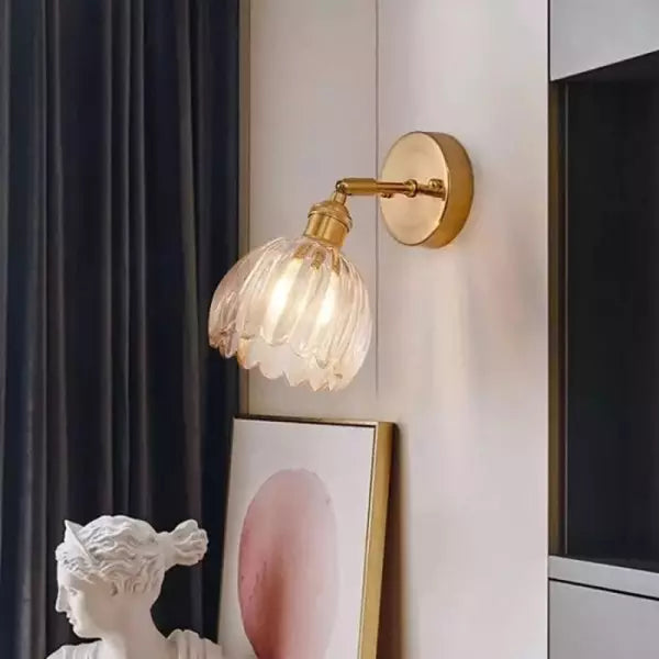 Vägglampa vintage i glas med tulpanformad skärm tänd i ett mörkt rum