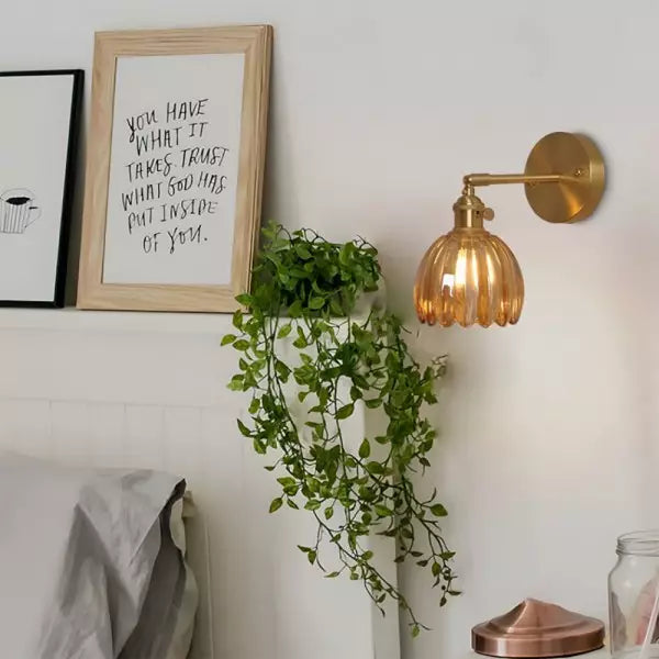Närbild på den tulpanformade glasskärmen på vintage vägglampa