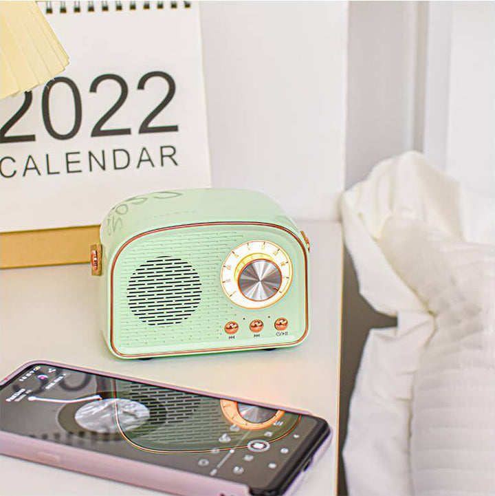 Trådlös retro bluetooth-högtalare med klassisk design placerad på ett träbord