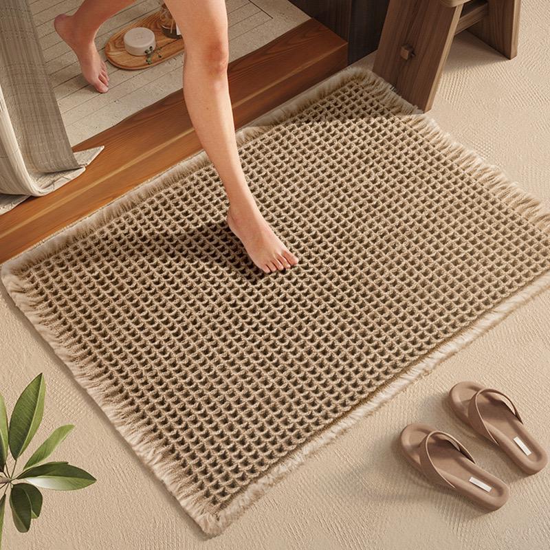 Texturerad absorberande entrématta i beige färg framför trädörr