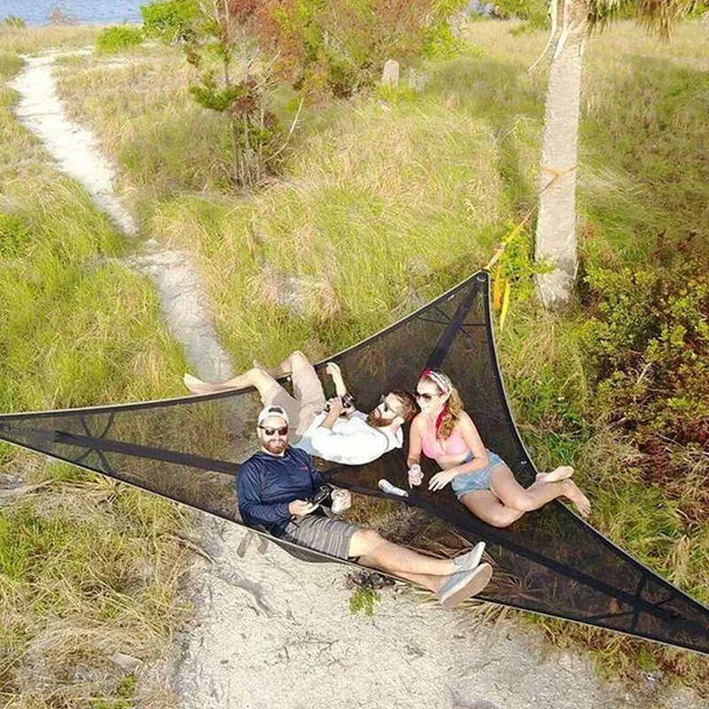 "Robust grön och svart nylonhängmatta för flera personer, perfekt för camping och utflykter, i naturlig miljö."