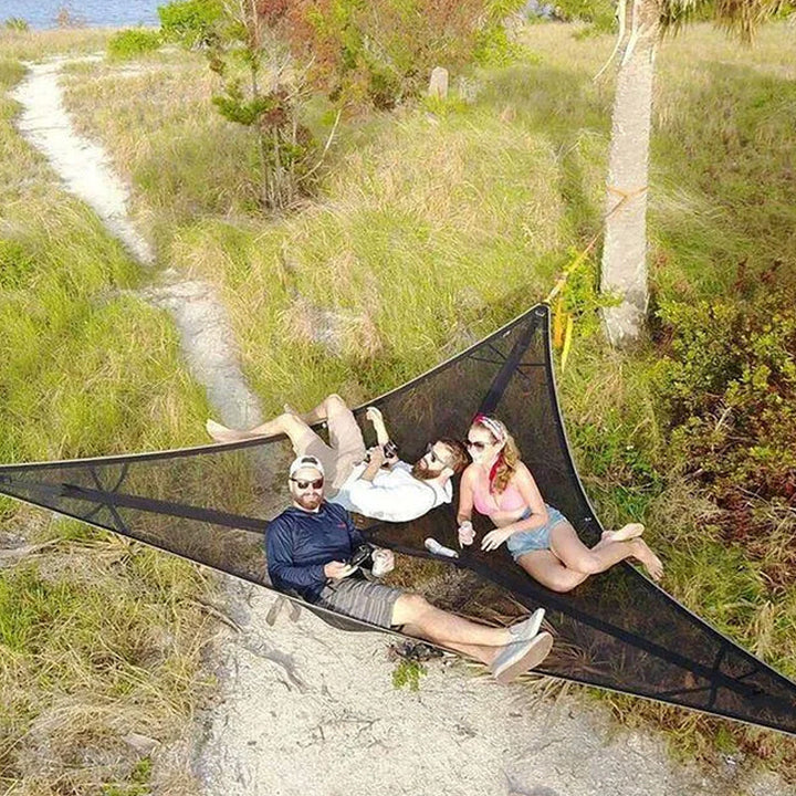 "Robust grön och svart nylonhängmatta för flera personer, perfekt för camping och utflykter, i naturlig miljö."