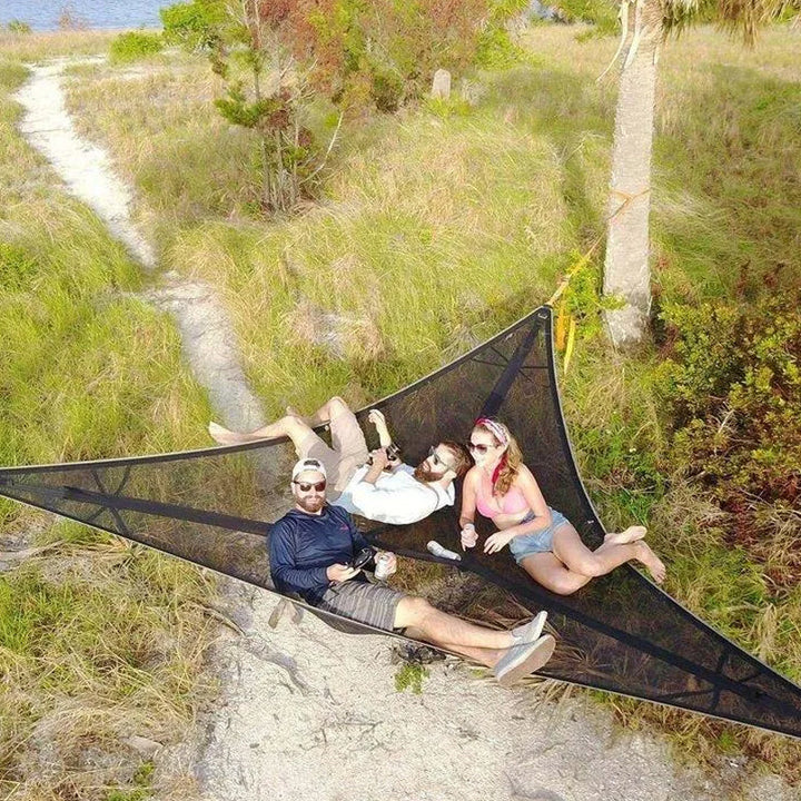 "Robust grön och svart nylonhängmatta för flera personer, perfekt för camping och utflykter, i naturlig miljö."