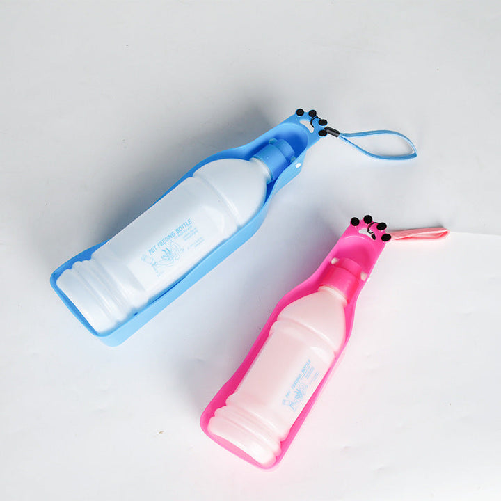 Glad hund dricker från rosa bärbar vattenflaska 600ml under utomhuspromenad. Idealisk för hydrering.