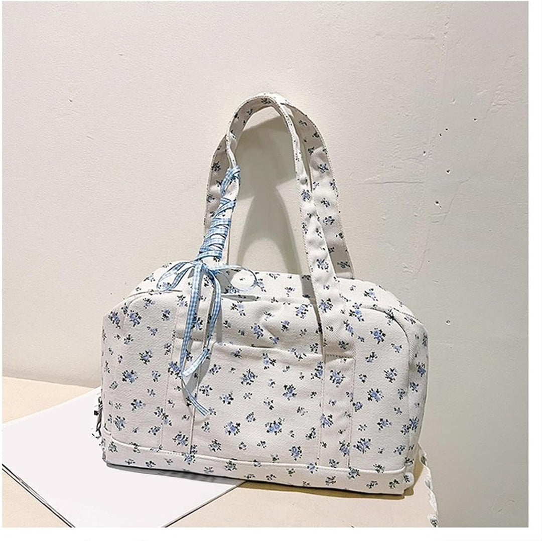 Rosa weekendväska i canvas med avtagbar axelrem. Stilfull duffelväska med rosett för handsfree-bärande.