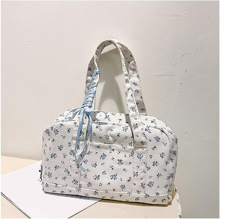 Rosa weekendväska i canvas med avtagbar axelrem. Stilfull duffelväska med rosett för handsfree-bärande.