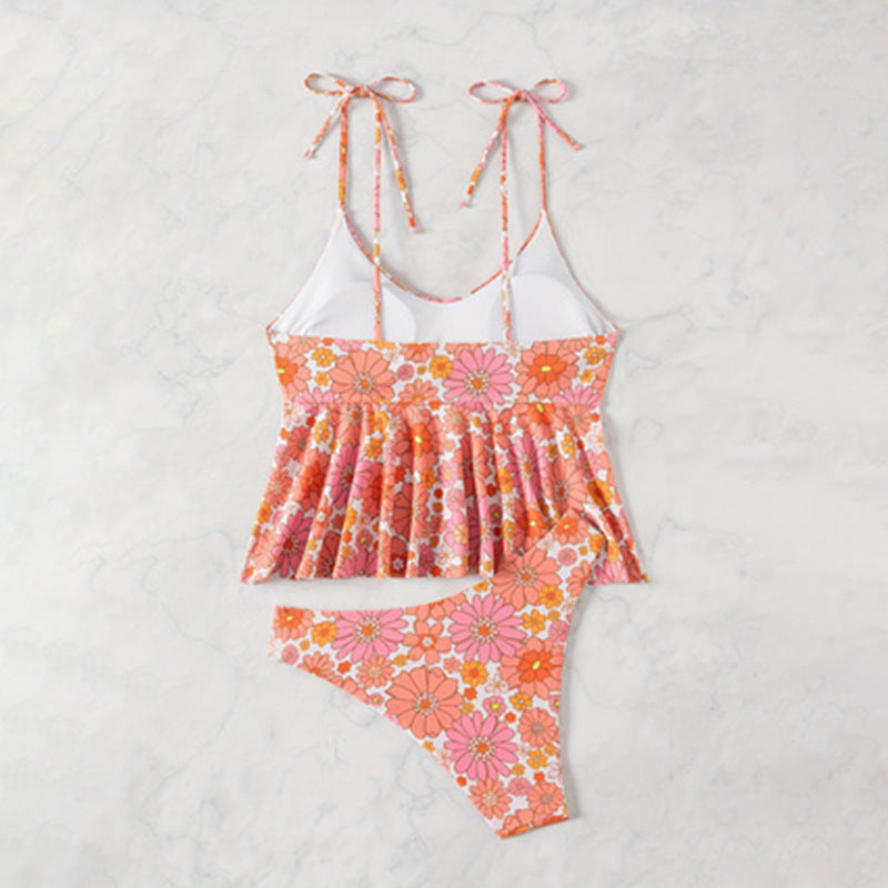 Modell bär rosa volangtankini med blommor. Modern dambaddräkt, idealisk strandkläder för sommar.