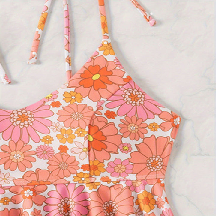 Bekväm rosa tankini med blommönster och volanger. Perfekt dambaddräkt för sommaraktiviteter vid stranden.