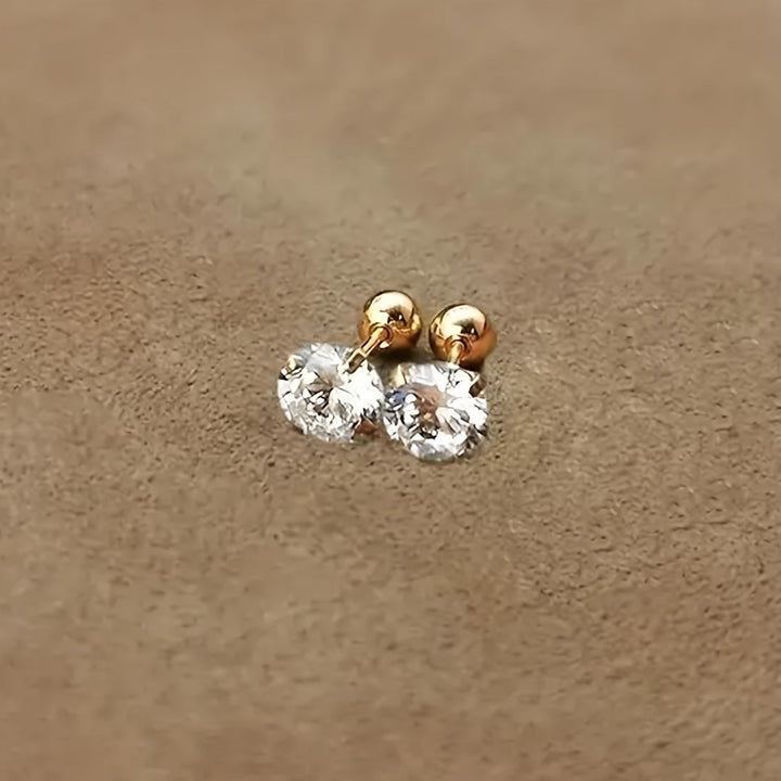 Närbild av glänsande runda zirkonia örhängen i titanstål. Minimalistiska, tidlösa unisex smycken.