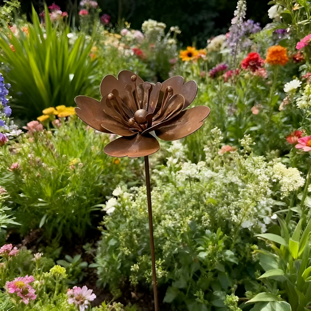 Närbild av rustik rostmetallblomma som trädgårdsstake. Elegant metallblomma för trädgårdsinredning.