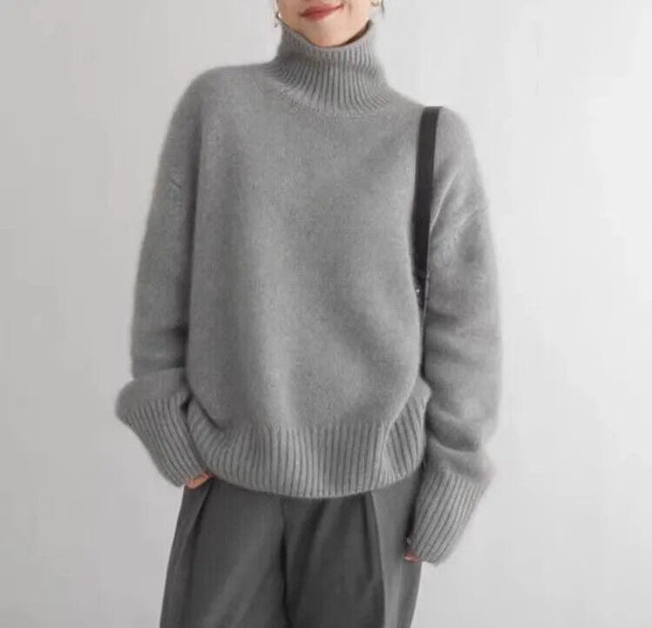 Kvinna i grå mjuk stickad turtleneck tröja med avslappnad passform