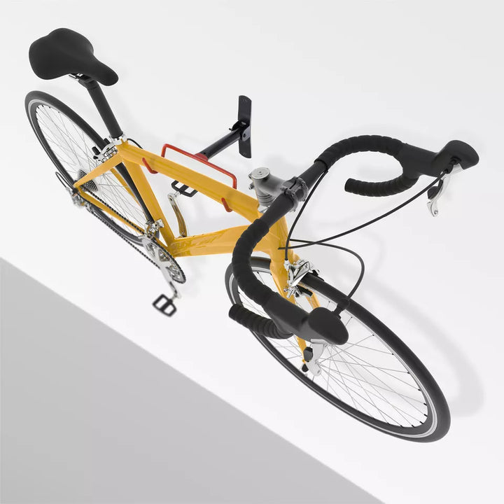 Väggmonterad cykelhållare monterad i garage med gul landsvägscykel