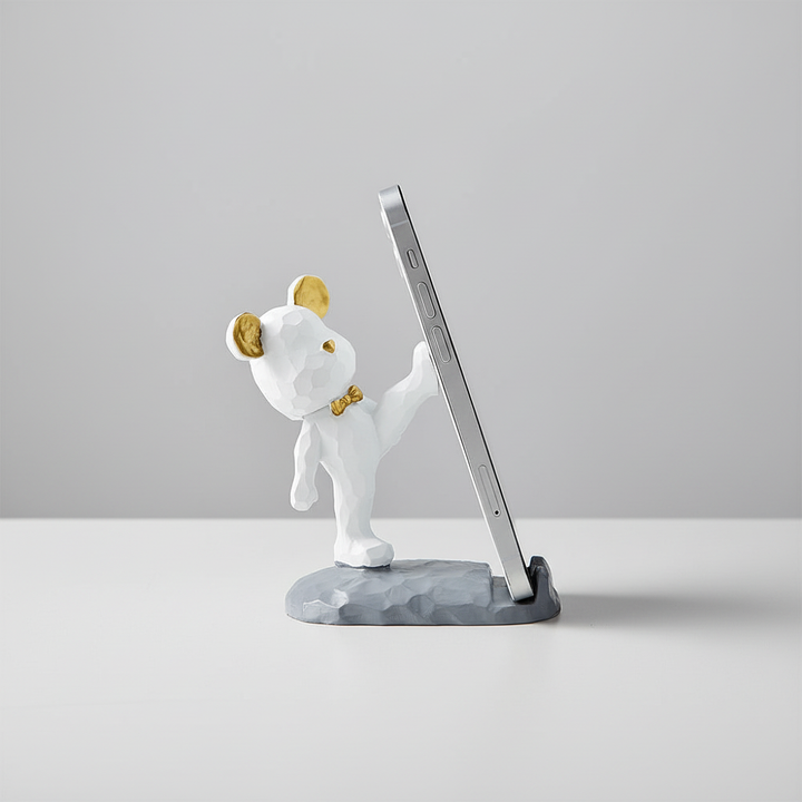 Charmig mobilhållare TeddyHolder på skrivbordet med en smartphone.
