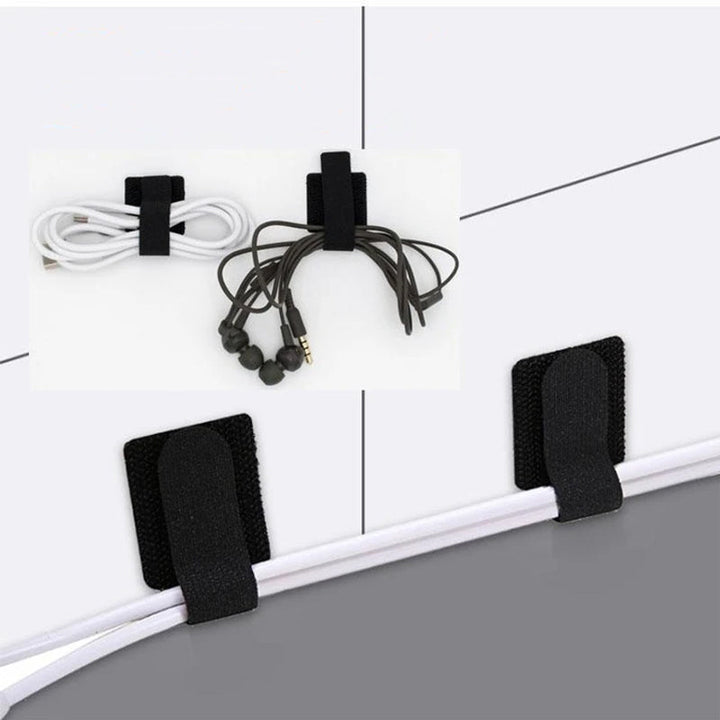 "Självhäftande kardborrearrangör för kablar, svart nylon, justerbar 28x90 mm, enkel installation på plana ytor."