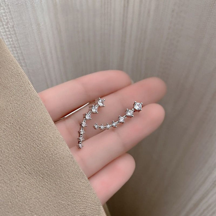 "Sju-stjärniga stiftörhängen med kristaller i guld, eleganta accessoarer för kvinnor, glänsande och sofistikerad design."