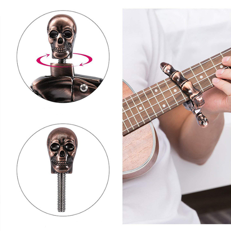 Skalleformad gitarrcapo i metall med unik design, perfekt för akustiska och elektriska gitarrer, finns i flera färger.