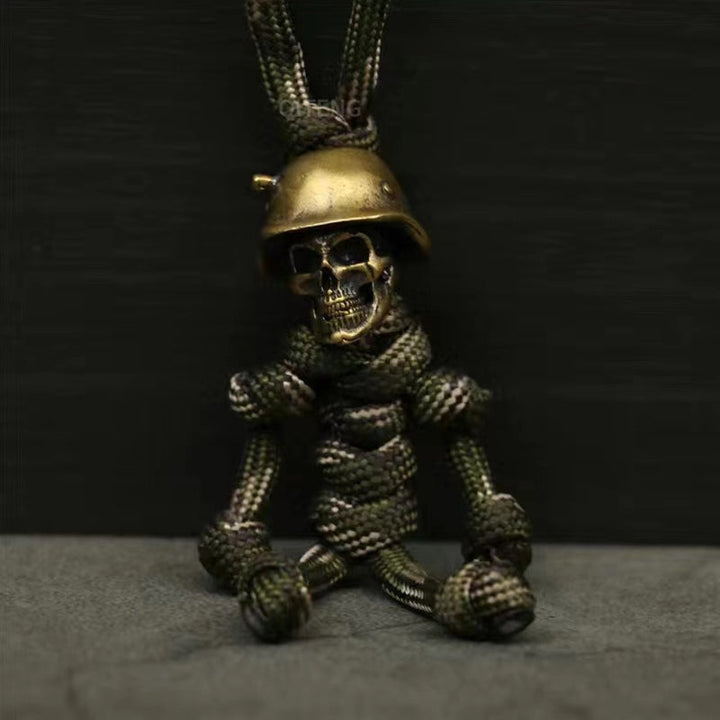 "Skelet soldat nyckelring i koppar och paracord, robust design med slitstark tygfläta och unik kopparlook."