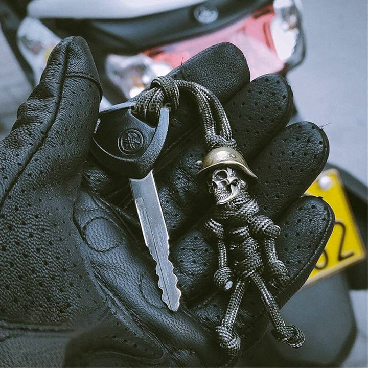 "Skelet soldat nyckelring i koppar och paracord, robust design med slitstark tygfläta och unik kopparlook."