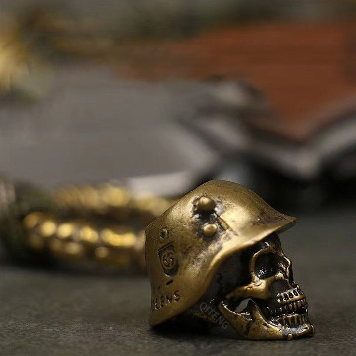 "Skelet soldat nyckelring i koppar och paracord, robust design med slitstark tygfläta och unik kopparlook."