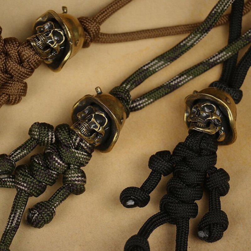 "Skelet soldat nyckelring i koppar och paracord, robust design med slitstark tygfläta och unik kopparlook."