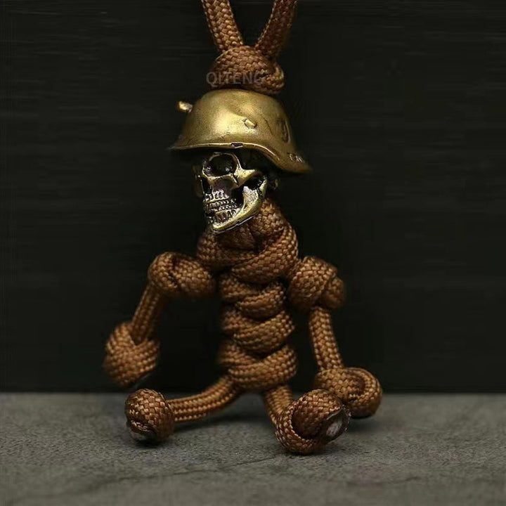 "Skelet soldat nyckelring i koppar och paracord, robust design med slitstark tygfläta och unik kopparlook."
