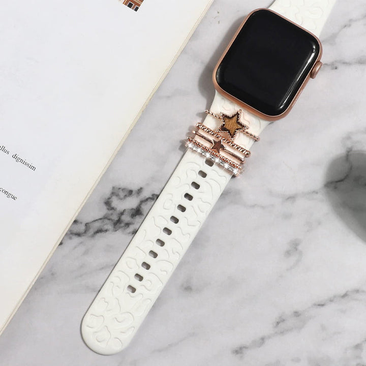 Smartklockband med dekorativa metallringar i gyllene leopardmönster och roséguldstjärnor, elegant stilaccessoar.
