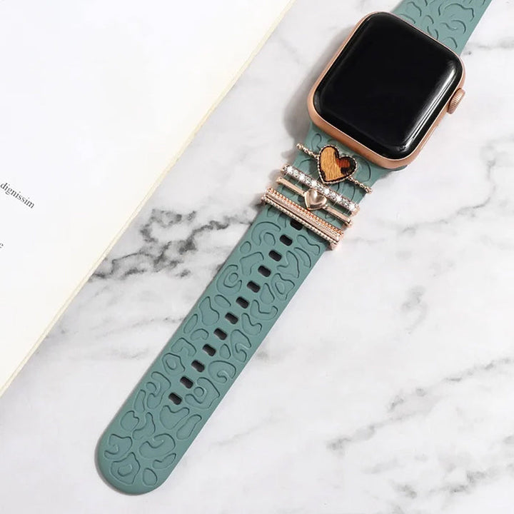 Smartklockband med dekorativa metallringar i gyllene leopardmönster och roséguldstjärnor, elegant stilaccessoar.