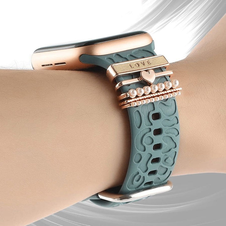 Smartklockband med dekorativa metallringar i gyllene leopardmönster och roséguldstjärnor, elegant stilaccessoar.