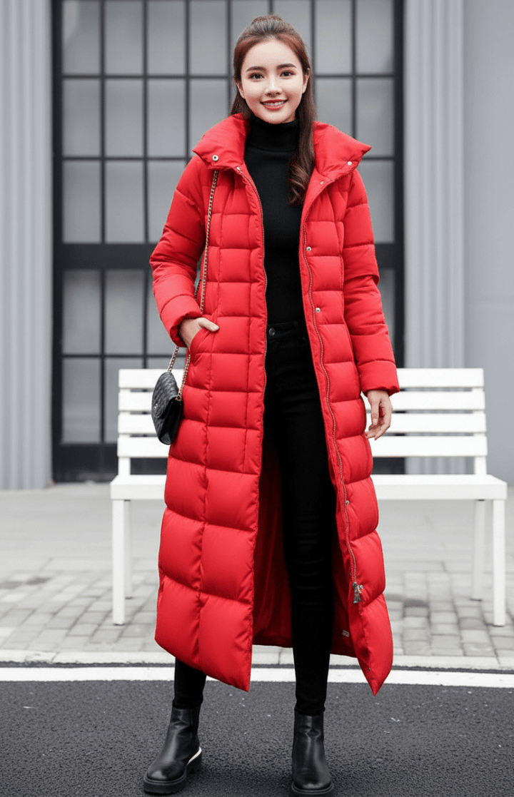 Modern lång damkappa Natalie med huva, vadderad design för maximal värme och stil. Perfekt ytterplagg i vinter.