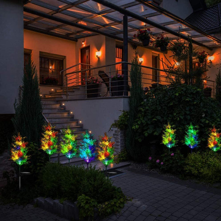"Solcellsdriven RGB trädgårdsbelysning för jul, naturinspirerad design med cypress- och tallbladseffekt, magisk atmosfär."