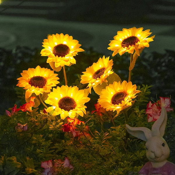 Solros solcellslampa med LED-belysning placerad i en grön trädgård