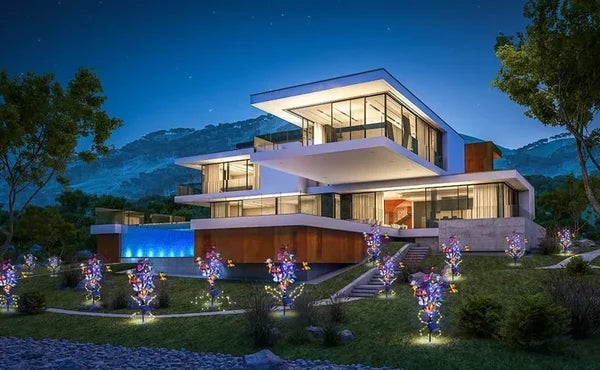 Exempel på hur flera solcellsdrivna fjärilslampor lyser upp en modern villa och trädgård