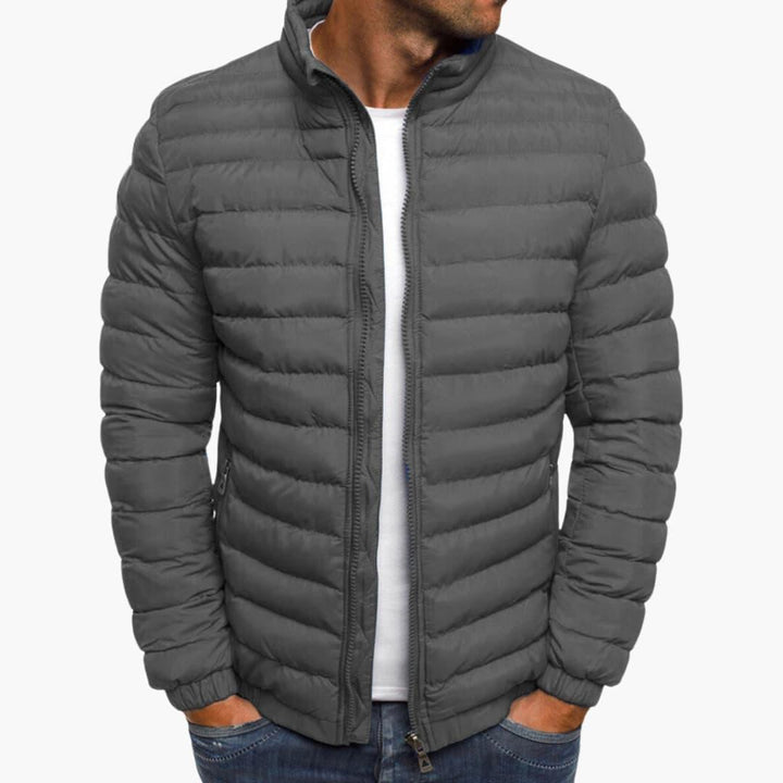 Quiltad herrjacka som passar casual outfits, med dragkedja och fickor, perfekt för vardag och fritid.