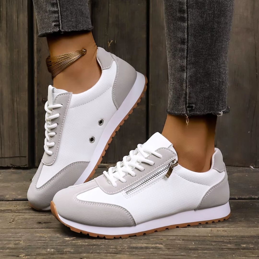 Vita dam sneakers med grå detaljer. Lätta komfortskor, idealiska för bekväma promenader och vardagsbruk.