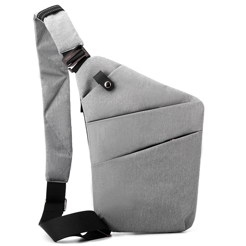 Ljusgrå crossbody-väska visad i vinkel med axelrem